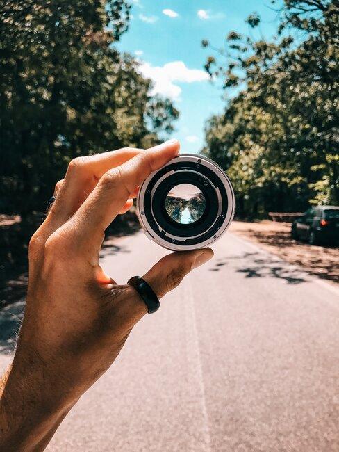 Osoba trzyma soczewkę do aparatu fotograficznego